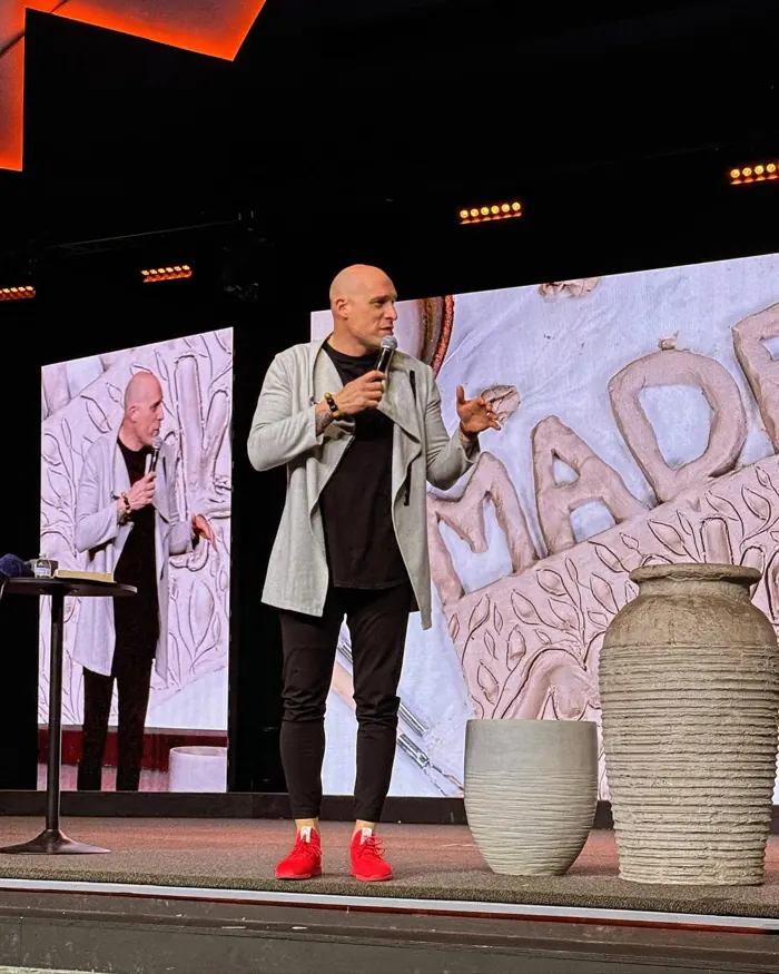 Speaker standing on a church stage in front of LED video walls