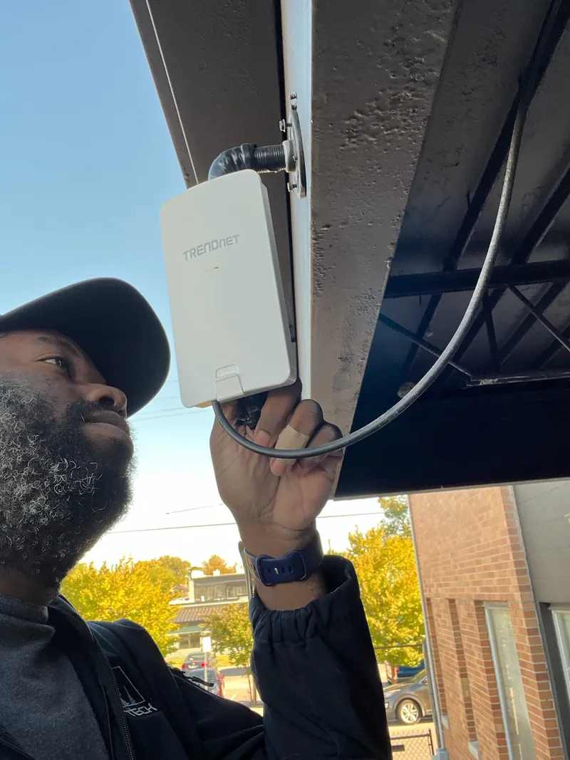 FM Tech technician installing an outdoor wireless network bridge for a commercial client