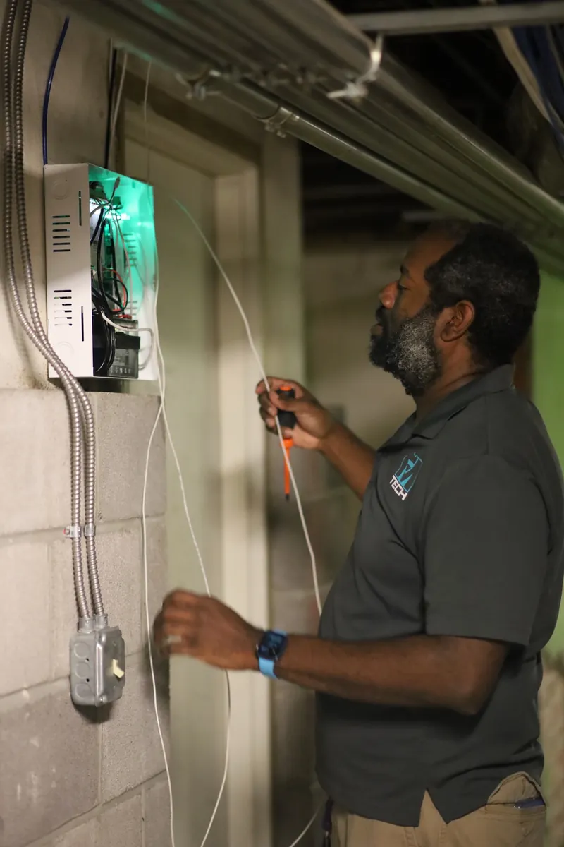 FM Tech technician installing a Paxton access control door controller at a church