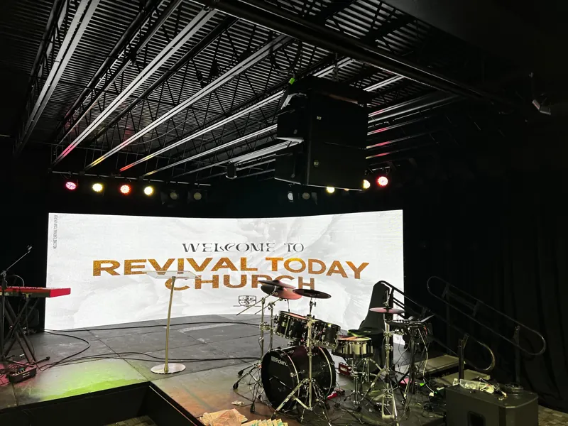 Church stage with a drum kit and a wide LED screen displaying a welcome message