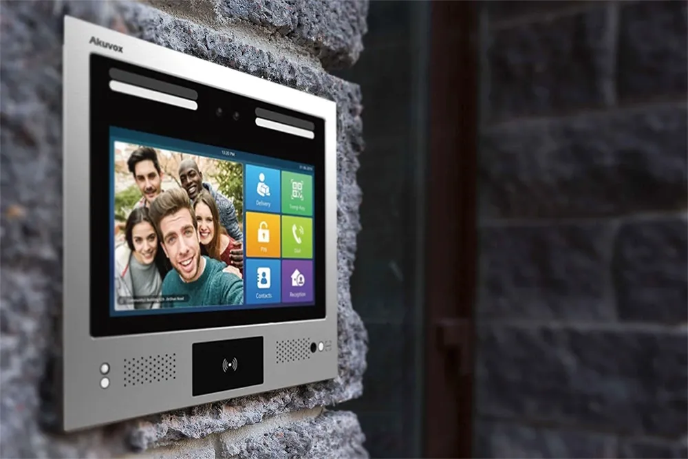 Touchscreen video intercom station with card reader mounted on a stone wall